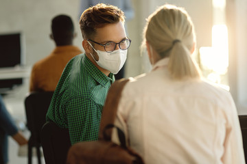 Poster - Happy student communicating with his friend while wearing face mask on a class in lecture hall.