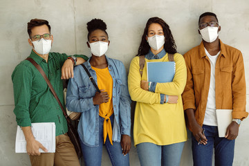 Wall Mural - Group of college students wearing protective face masks while standing against the wall.