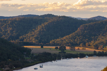 Canvas Print - golden light over the hill next to the river.
