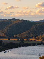 Canvas Print - golden light over the hill next to the river.