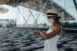 © Эллона Крицкая - Travel tourist woman in madical mask standing near airport building. Travel lifestyle.