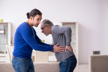 Young man looking after his sick father