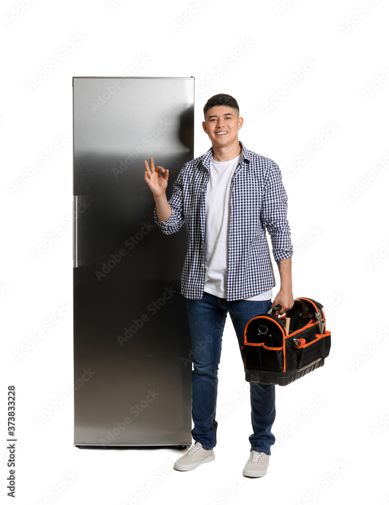 Worker of repair service near fridge on white background