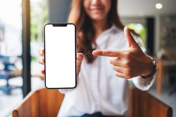 mockup image of a beautiful woman pointing finger at a mobile phone with blank white screen