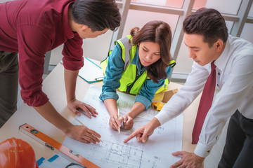 Construction team with business man engineer and architect is brainstorming on working table with building plan