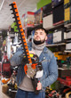 © JackF - serious man with an electric brush cutter in hardware store