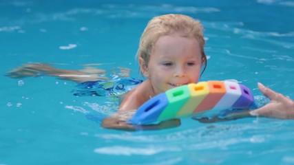 Sticker - Cute toddler boy, swimming in pool with board