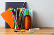 Schulbedarf mit Seifenspender und blauen Mundschutz auf einem Holztisch. Neue Normalität, Schulbeginn.