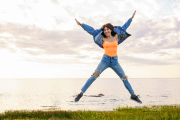 a girl jumps on the background of the sea on a summer day