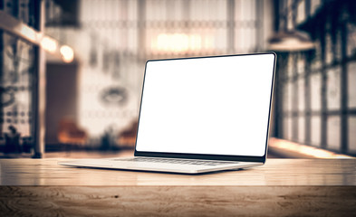 Laptop with frameless blank screen mockup template, rotated position on table in industrial office loft interior - front view