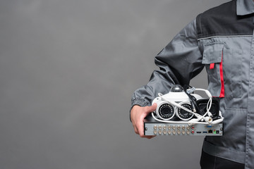 Wall Mural - CCTV camera equipment in the engineer hands close up on gray background.