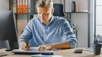 Canvas Print - Handsome Blonde Businessman Sitting at His Desk in the Office Works on Desktop Computer, Working with Documents, Charts, Graphs, Statistic and Strategy. Creative Entrepreneur Using Computer