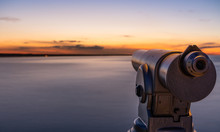 A Telescope On A Lookout At A Beautiful Sunset And A Long Exposure Of The Water On The Sea.