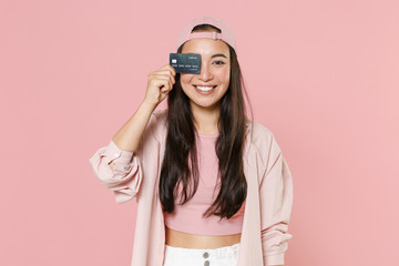 Wall Mural - Smiling young asian woman girl in casual clothes cap posing isolated on pastel pink wall background studio portrait. People lifestyle concept. Mock up copy space. Covering eye with credit bank card.