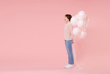 Full Length Portrait Side View Of Shocked Young Woman In Casual Sweater Isolated On Pastel Pink Background. Birthday Holiday Party People Emotions Concept. Celebrating Hold Air Balloons Looking Aside.
