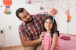 © Antonio Recena - Father combing his daughter's hair in the bedroom at home