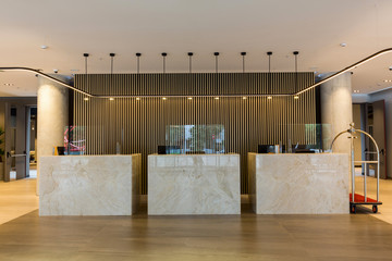 Interior of a hotel lobby with reception desks with transparent covid plexiglass lexan clear sneeze guards