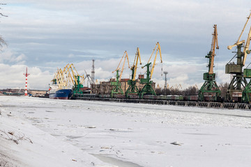 Huge green industrial cranes at the seaport in winter