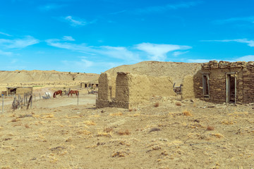 Wall Mural - old stone and adobe buildings with horses at cabezon new mexico usa