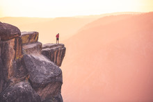 A Male Hiker Stands At The Edge Of A Cliff At Taft Point, Yosemite National Park, California