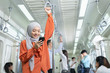 © godji10 - Beautiful Muslim woman playing mobile phone on her way to work. Business people, Company staff, workers using cellular in subway or sky train. Concept of 5G communication technology,internet networks
