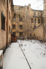 The courtyard of an old apartment building in St. Petersburg with yellow shabby walls