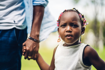 Portrait of enjoy happy love black family african american father holding little african girl hand in moments good time in summer park at home