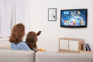 Sticker - Mother and daughter watching smart TV in living room