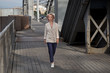 © Алексей Васильев - A young woman in a business suit walks across the bridge.