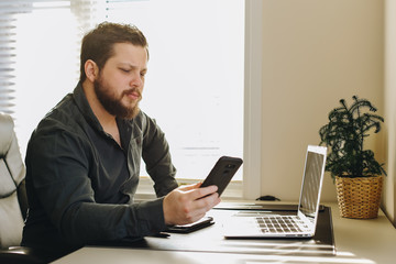 Wall Mural - Male manager using smatrphone and laptop working at office.
