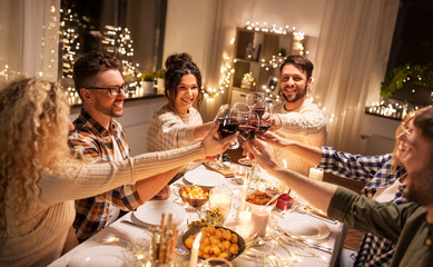 Canvas Print - holidays, celebration and people concept - happy friends having christmas dinner at home drinking non-alcoholic red wine