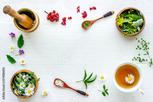 Fototapeta na drzwi i meble Top view of herbal tea in cup with herbs in bowls, top view