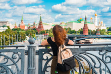 Rear View Of A Woman With Backpack Standing On A Bridge In Front Of The Kremlin In Moscow, Russia