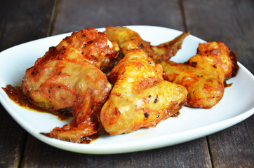 Wall Mural - appetizing toasted plate of chicken wings on brown wooden table Crispy Buffalo Chicken Wings baked. Cafe Delites takeaway, restaurant or cafe menu