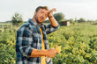 © LIGHTFIELD STUDIOS - exhausted farmer in checkered shirt touching forehead while looking at camera