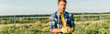 © LIGHTFIELD STUDIOS - horizontal image of farmer in checkered shirt and gloves holding fresh potatoes while standing on field