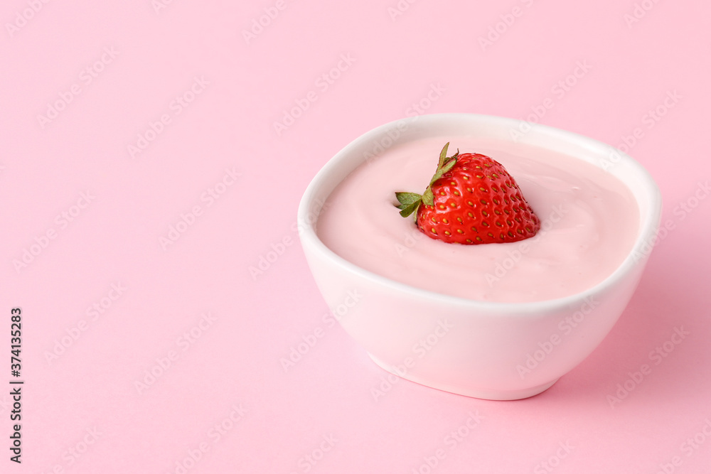 Bowl of strawberry yogurt on color background