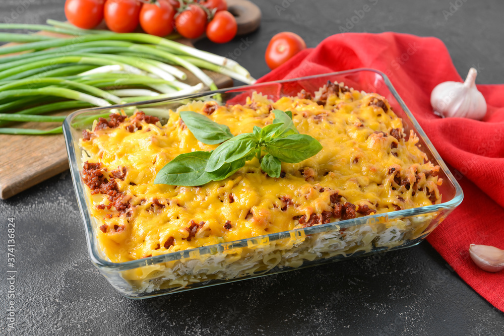 Baking dish with tasty beef casserole on dark background