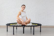 Relaxed woman sitting on trampoline