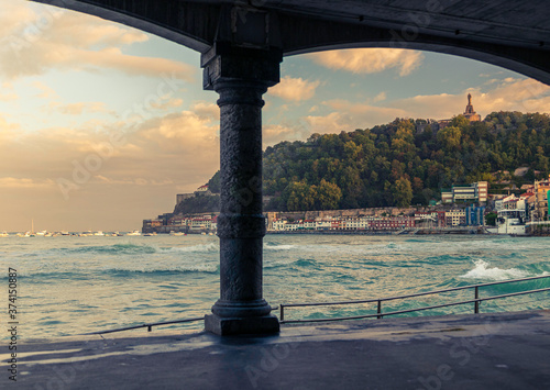 Fotomural first lights of day in the arcades of la cocha beach in san sebastian, spain