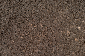 Seamless dark brown compost fertiliser texture background.