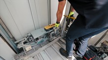 Young Man Mechanic Engineer Working Doing Maintenance On Elevator Lift At Construction Site Slow Motion