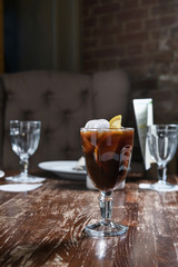 Wall Mural - coffee with ice and lemon on a wooden table