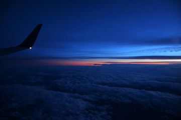 Sticker - Beautiful shot of an airplane flying above white clouds at sunset