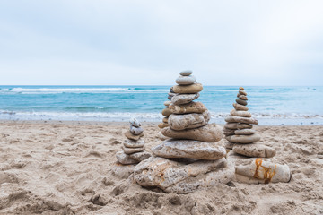 Poster - Pebbles stacked on each other in a balance at the beach