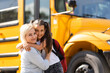 © Angelov - Mother brings her daughter to school near the school bus. back to school