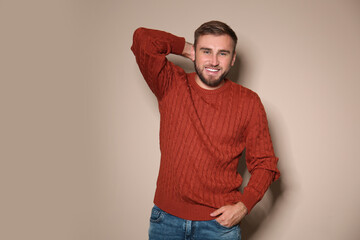 Poster - Handsome man wearing warm sweater on beige background