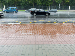 Wall Mural - cars crossing a flooded road after strong rain with thunderstorm. blurred motion