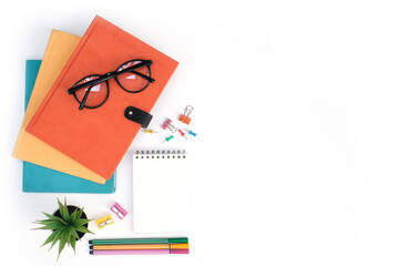 Wall Mural - Flat lay, Workspace education and back to school concept on white modern table desk with stack of book and blank note pad, green plant and stationery, Top view with copy space