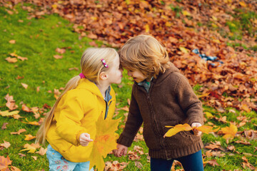 Sticker - Happy children having fun in autumn park outdoors. Boy and girl kissing.